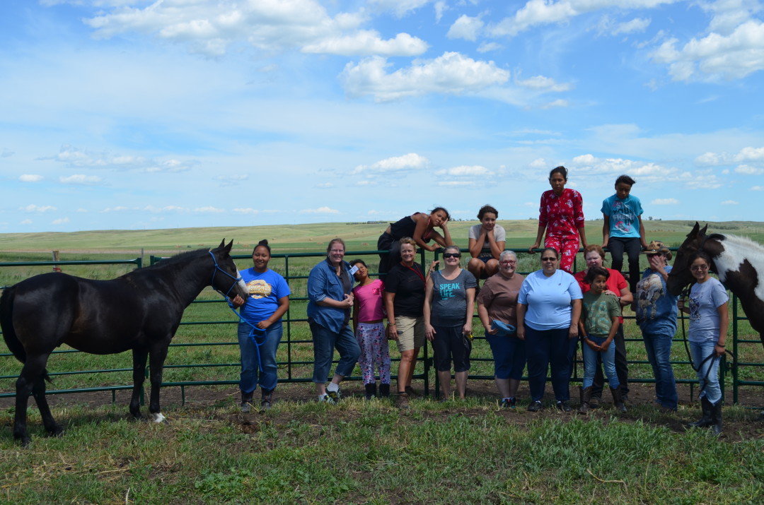 Women and girls with horses on the prairie at Horse Camp